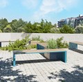 Banc public sans dossier 4 places Indre By installé sur une terrasse pavée avec des plantes environnantes.