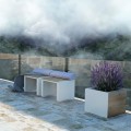 Indre By Outdoor Stool on a patio with a lavender plant.