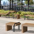 Vesterbro Outdoor Stool | Oak in a park setting with other matching oak furniture.