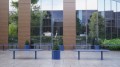 Jardinière d'extérieur Sydhavn bleue de 55 l placée sur une terrasse moderne devant un bâtiment vitré.