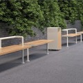 Banc Public Sans Dossier Holmen 3 Places en bois et métal dans un parc urbain entouré de verdure.