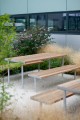 Banc Public Sans Dossier Holmen 3 Places en bois et métal dans un jardin moderne.