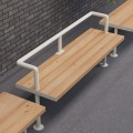 Holmen 3 Seater Public Backrest Bench in a public setting with a brick wall backdrop.