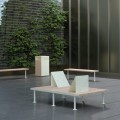 Holmen 2 Seater Public Lounge Bench in a modern outdoor setting with greenery in the background.