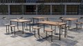 Table d'extérieur Holmen 150 cm avec chaises en métal et bois, convenant pour 4 à 6 personnes, placée sur une terrasse pavée.