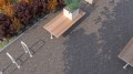 Fahrradständer Holmen U-Form auf grauem Boden neben Holztisch und Pflanzen.