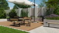 Nordhavn 3-Sitzer Sitzbank mit Rückenlehne auf einer Terrasse im öffentlichen Bereich, umgeben von Pflanzen.