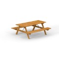 Grande table en bois avec bancs intégrés pour jardin ou terrasse.