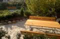 Bank & Tisch (verzinkter Stahl) im Garten, von Pflanzen umgeben.