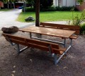 Banc et table en acier galvanisé avec assises en bois dans un parc.