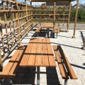 Banc et table en bois sur structure en acier galvanisé dans un jardin.