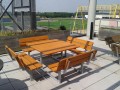 Quadratische Bank & Tisch aus Holz auf Terrasse im Freien.