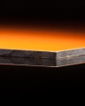 Close-up of HPL PLATE ORANGE thickness 6 mm (SAMPLE 50×50 MM) showing the edge and layers.