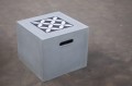 Concrete cube with decorative white and black patterned top.
