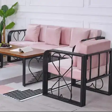 Edelstahltisch-Sofa mit rosa Kissen im modernen Wohnzimmer.