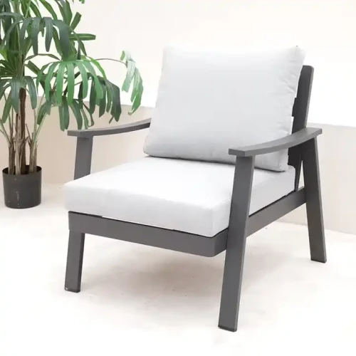 Black metal dining chair with white cushions next to a plant pot.