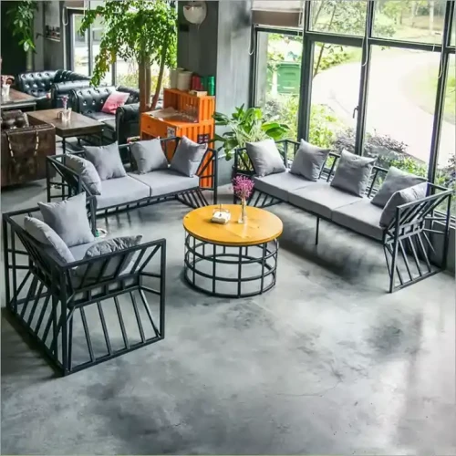 Mobilier moderne pour salon en métal avec matelas, ensemble de canapés et table basse ronde, vue intérieure.