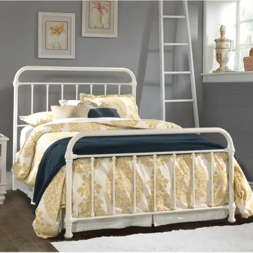 Lit simple en métal blanc avec draps à motifs dorés dans une chambre moderne.