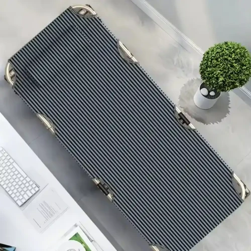 Klappbares Metallbett auf minimalistischer Einrichtung.