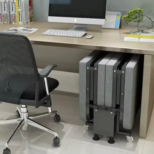 Lit en métal moderne pliable gain de place rangé sous un bureau.