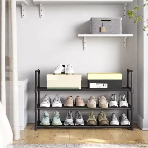 Étagère à chaussures en métal moderne dans une entrée, avec plusieurs paires de chaussures.
