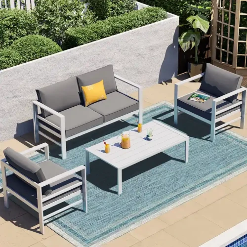 Mobilier de jardin moderne en métal avec table blanche et chaises grises sur terrasse extérieure.