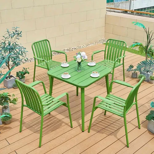 Ensemble de chaises de jardin en métal vert avec table sur terrasse en bois, design moderne.
