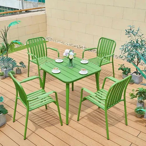Ensemble de meubles de jardin vert moderne avec table et chaises sur terrasse en bois.