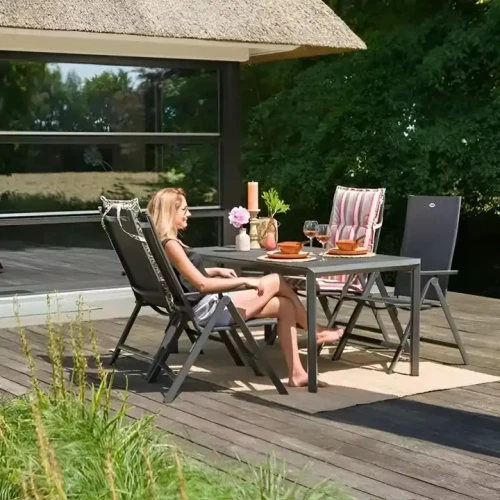 Chaise pliante de jardin en métal moderne sur une terrasse, partie d'un ensemble de meubles de patio d'extérieur.