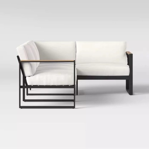Modern black metal patio sofa set with white cushions.