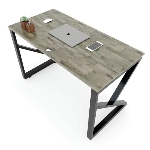 Bureau moderne avec plateau en bois et pieds en métal noir, incluant un ordinateur portable, un smartphone et un pot de plantes.