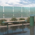 Nordhavn 4 Seater Public Backless Bench on a paved outdoor area next to a trash bin.