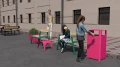 Girl disposing trash in Ørestad Street Litter Bin in outdoor urban setting.