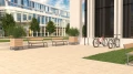 Amager 3 Seater Public Backless Bench in a modern outdoor plaza with surrounding plants and bicycles.