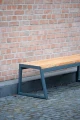 Amager 3 Seater Public Backless Bench against a brick wall.