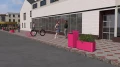 Ørestad Cykelstativ i lyserød farve monteret på en fortov.