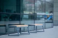 Amager 4 Seater Public Backless Bench outside a modern glass building.