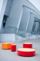 Valby Public Backless Bench | Round in red and orange in a modern urban setting