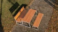 Frederiksberg 4 Seater Public Backless Bench with matching wooden table and bench set in a park.