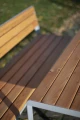 Frederiksberg Outdoor Table 180 cm 6-8 Seats with wooden slats and metal frame in a garden.