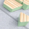 Outdoor stool Kødbyen 45 cm with a green base and wooden seat on a concrete surface.
