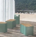 Kødbyen Street Litter Bin next to modern outdoor benches on a sunny wooden terrace with a beach in the background