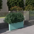 Stor udendørs Kødbyen Udendørs Plantebeholder med 150 l kapacitet, fyldt med grønt buskads, placeret i en moderne gårdhave.
