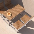 Hellerup 1 Person Backrest Bench next to a wooden outdoor dining table with a fruit bowl.