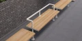Holmen 3 Seater Public Backrest Bench against brick wall in outdoor setting.