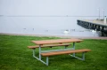 Bænk &amp; bord (galvaniseret stål) ved vandet i en park.