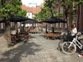 Rundt havebord og bænk sæt med sort parasol, Firkantet Bænk &amp; Bord på en udendørs plads.