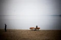 Person sidder ved et Firkantet Bænk &amp; Bord på en strand.