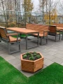 Træblomsterpotte IV på terrasse med træbænke og borde.