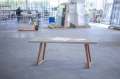 Concrete table with wooden legs in a workshop.